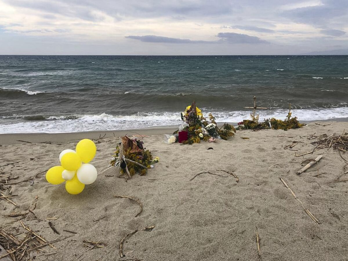Flowers are left where the wreckage of a capsized boat washed ashore at a beach near Cutro, southern Italy, Thursday, March 9, 2023. Over 70 people died in last week's shipwreck on Italy's Calabrian coast. The tragedy highlighted a lesser-known migration route from Turkey to Italy for which smugglers charge around 8,000 euros per person. (Ronny Gasbarri/LaPresse via AP)