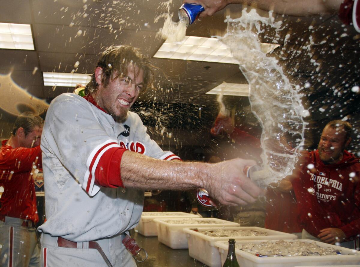 Jayson Werth sprays teammates as the Phillies celebrate their playoff win over the Rockies in 2009.