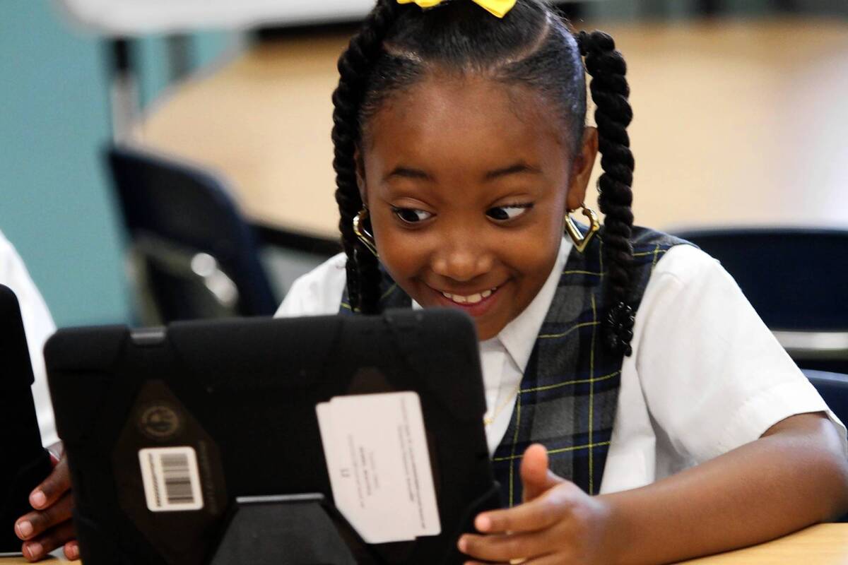Beautiful Morris smiles as she explores her new iPad. Although L.A. Unified originally said keyboards weren't essential, new state tests can't be taken on iPads without them.