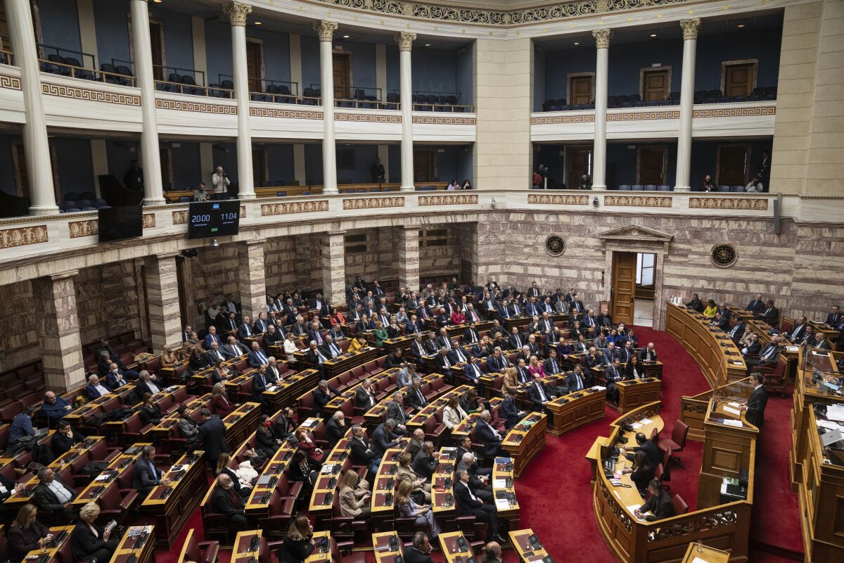 El primer ministro griego Kyriakos Mitsotakis, derecha, habla en un debate parlamentrio sobre un voto de censura, 27 de enero de 2023 en Atenas. (AP Foto/Petros Giannakouris)