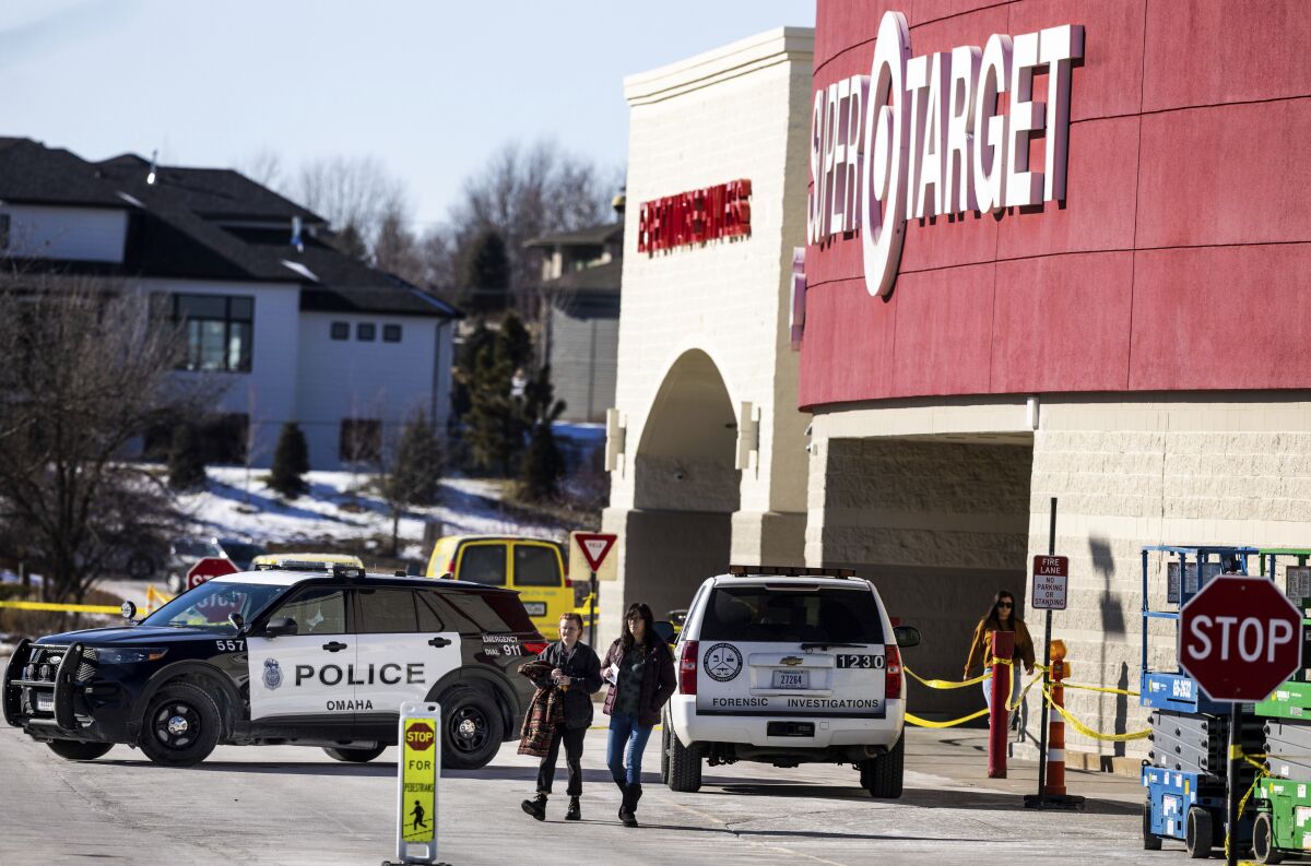 Customers and employees gathered so they can retrieve their belongings on Wednesday, Feb. 1, 2023, a day after they fled the Target store after someone walked in and started firing an assault rifle. Omaha police shot and killed the suspect. (Chris Machian/Omaha World-Herald via AP)