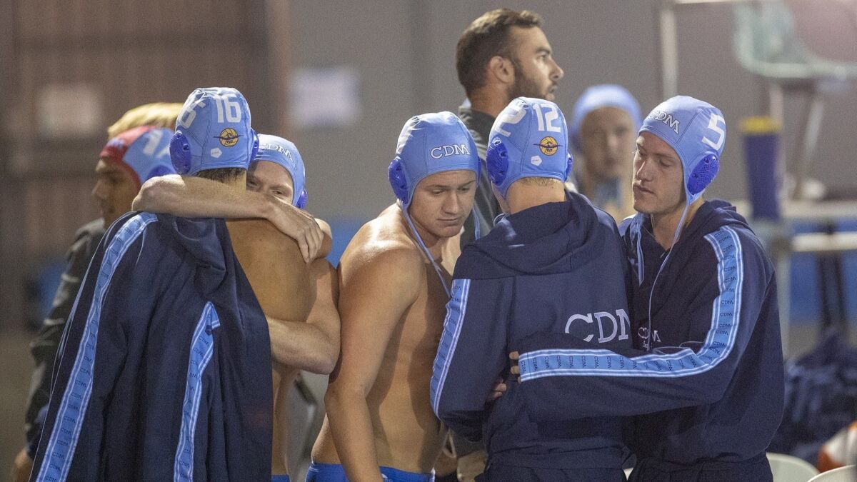 Corona del Mar High players hug following a 12-10 overtime loss to Foothill in a CIF Southern Section Division 2 semifinal playoff game at Woollett Aquatic Center in Irvine on Wednesday.