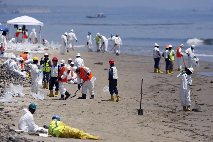 A beach cleanup crew at the shoreline of Refugio State Beach in Goleta on June 1. Lawmakers have proposed tougher rules to prevent spills.
