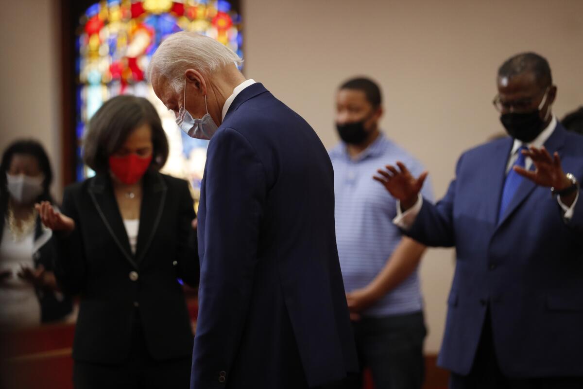 Former Vice President Joe Biden, wearing a mask, bows his head during a June 1 visit to Bethel AME Church in Wilmington, Del.