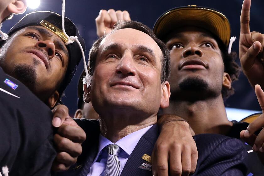 Duke Coach Mike Krzyzewski celebrates with his players after the team's NCAA championship victory over Wisconsin on Monday.