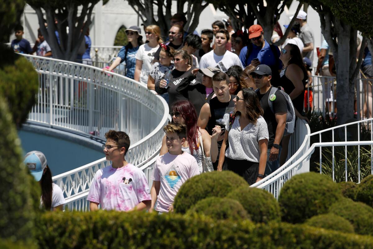 Lawsuits in California and Florida take aim at the 2013 decision by Disney to end a policy that gave visitors with disabilities and their family members a "Guest Assistance Card," allowing them to go directly onto rides. Above, visitors wait in line for the "It's a Small World" attraction at Disneyland.