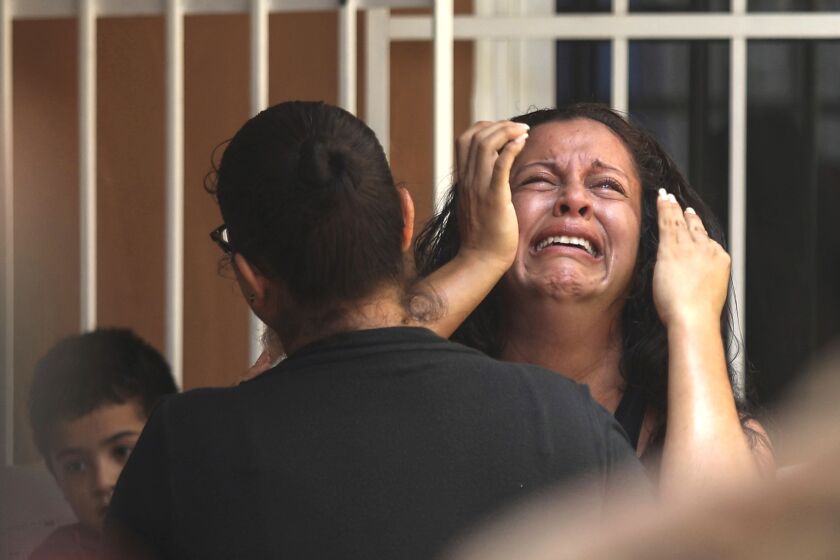 The mother of Alfredo Gonzalez Munoz a Mexican soldier that died during a massive gun battle in the city of Culiacan between drug cartel gunmen and members of the army and the police, cries during her son's wake in Veracruz, Mexico, Saturday, Oct. 19, 2019. The gunfight in the city of roughly 800,000 residents was triggered Thursday by an attempt to arrest Ovidio Guzman, son of convicted drug lord Joaquin "El Chapo" Guzman Loera, in response to a U.S. request for extradition. (AP Photo/Felix Marquez)