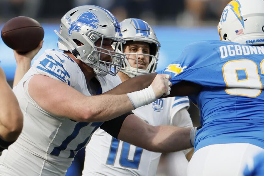 Detroit Lions quarterback Jared Goff passes in front of Chargers defensive tackle Otito Ogbonnia.