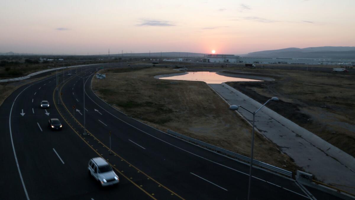 The sun rises over Honda automotive plants along an industrial corridor in Guanajuato.