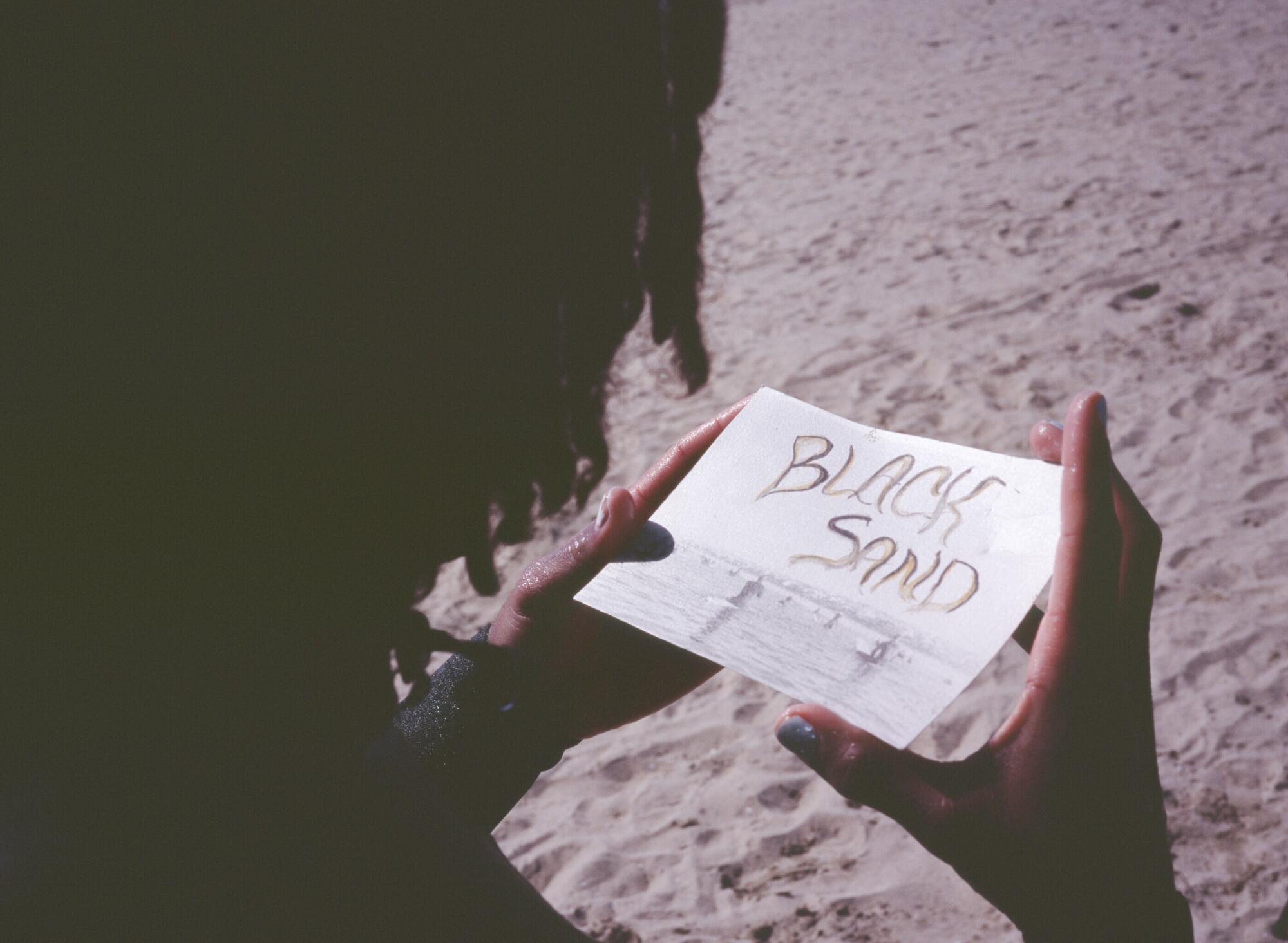 Gage Crismond looks at a photograph created by Chanae Owens of the Black Sand Paddle out.