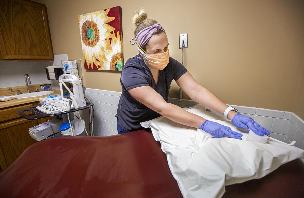 A woman disinfects a bed.