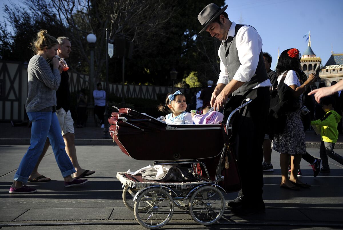 Eric Gonzalez of Eastvale has his 17-month-old daughter Erica set up in an old-fashioned baby carriage for their Dapper Day at Disneyland.