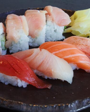 A horizontal closeup of a sushi lunch set at Ikigai on a black plate.