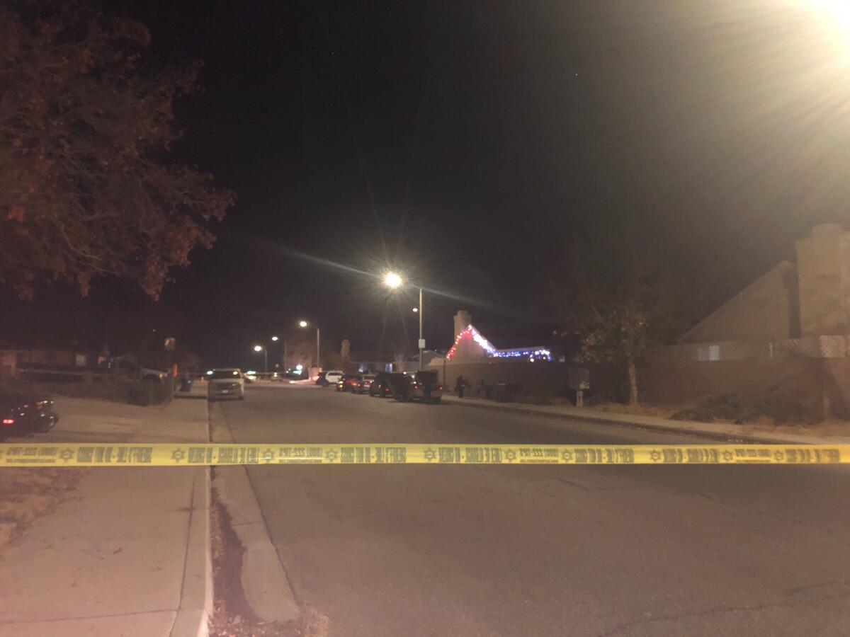 Yellow crime scene tape stretched across a residential street