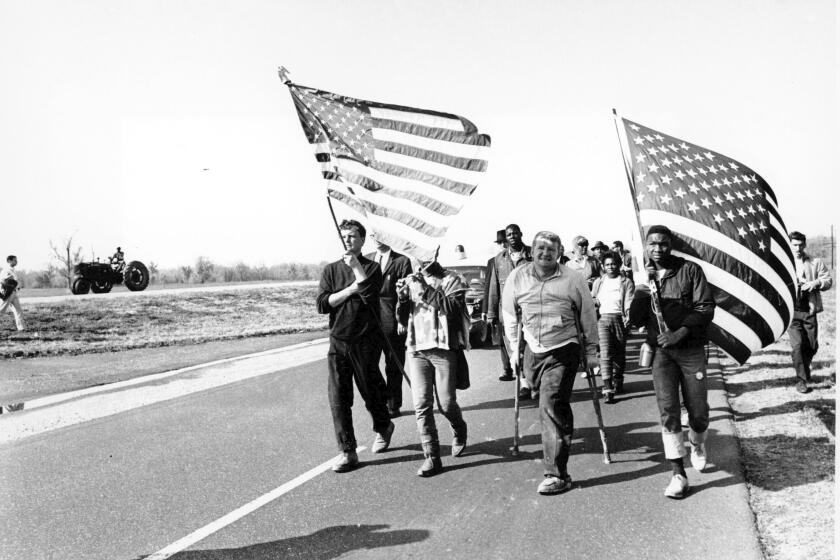 FILE - In this March 24, 1965, file photo, civil rights marchers carry flags and play the flute as they approach their goal from Selma to Montgomery, Alabama's state Capitol. A new online project by the Hutchins Center for African and African American Research at Harvard University seeks to bring the lessons of voting rights to students. The center unveiled in March 2020 Selma Online. Harvard scholar Henry Louis Gates Jr. says the project will engage students at home because of the coronavirus outbreak and comes as the nation prepares for a presidential election. (AP Photo, File)