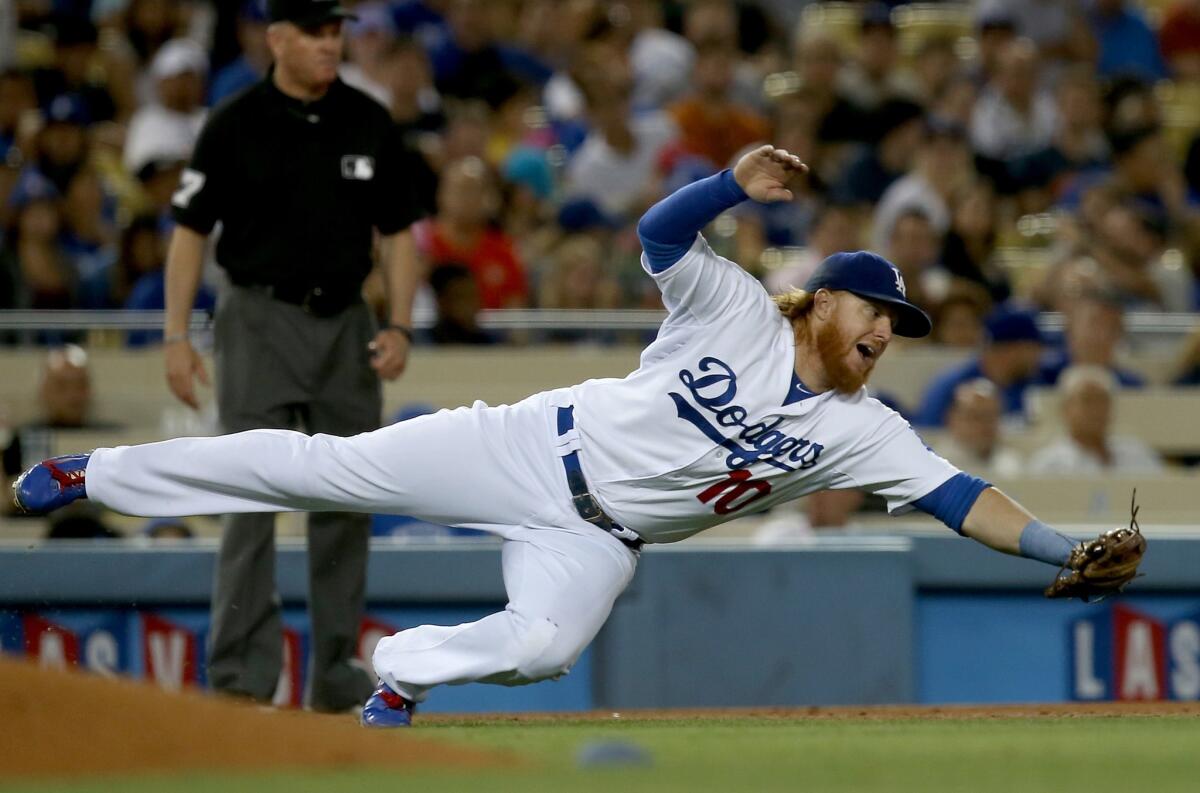 Justin Turner dives for a ball hit by San Diego's Abraham Almonte in the seventh inning of the Dodgers' 2-1 win Thursday night over the Padres.