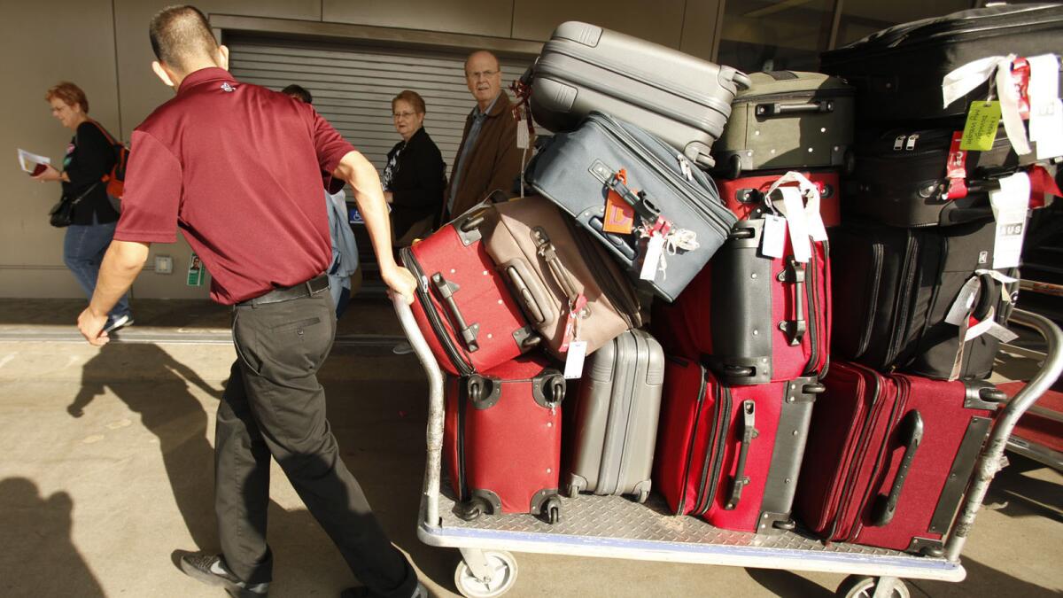 A baggage handler hauls a load at LAX.