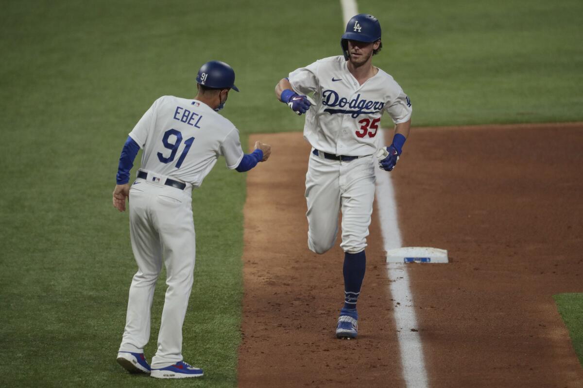 Cody Bellinger is greeted by third base coach Dino Ebel after homering in Game 2. 