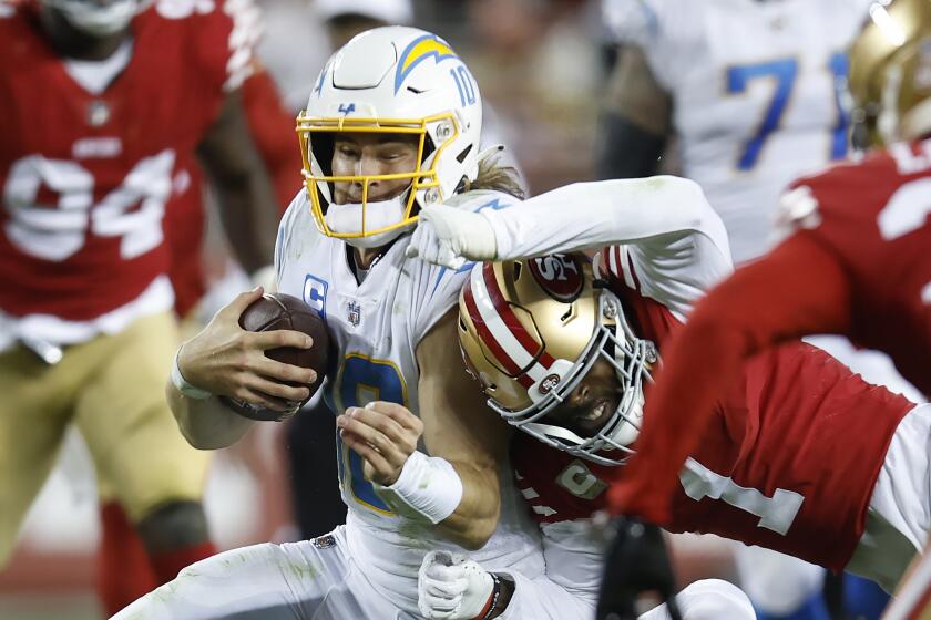 Los Angeles Chargers quarterback Justin Herbert (10) is hit by San Francisco 49ers cornerback Jimmie Ward.