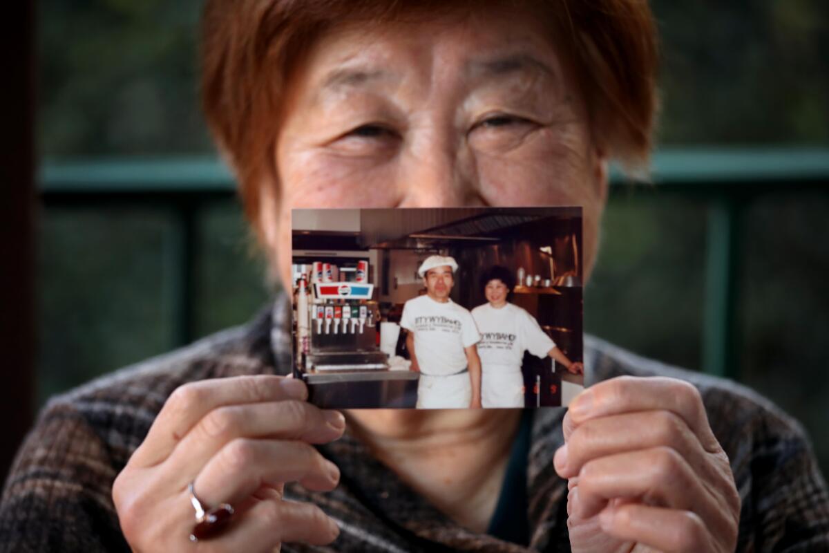 Atsuko Nagumo holds a photograph of herself and husband Sadao.