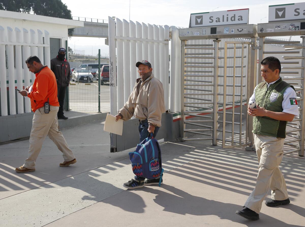 Migrant Carlos Catarldo Gomez, of Honduras, center, is escorted by Mexican officials 