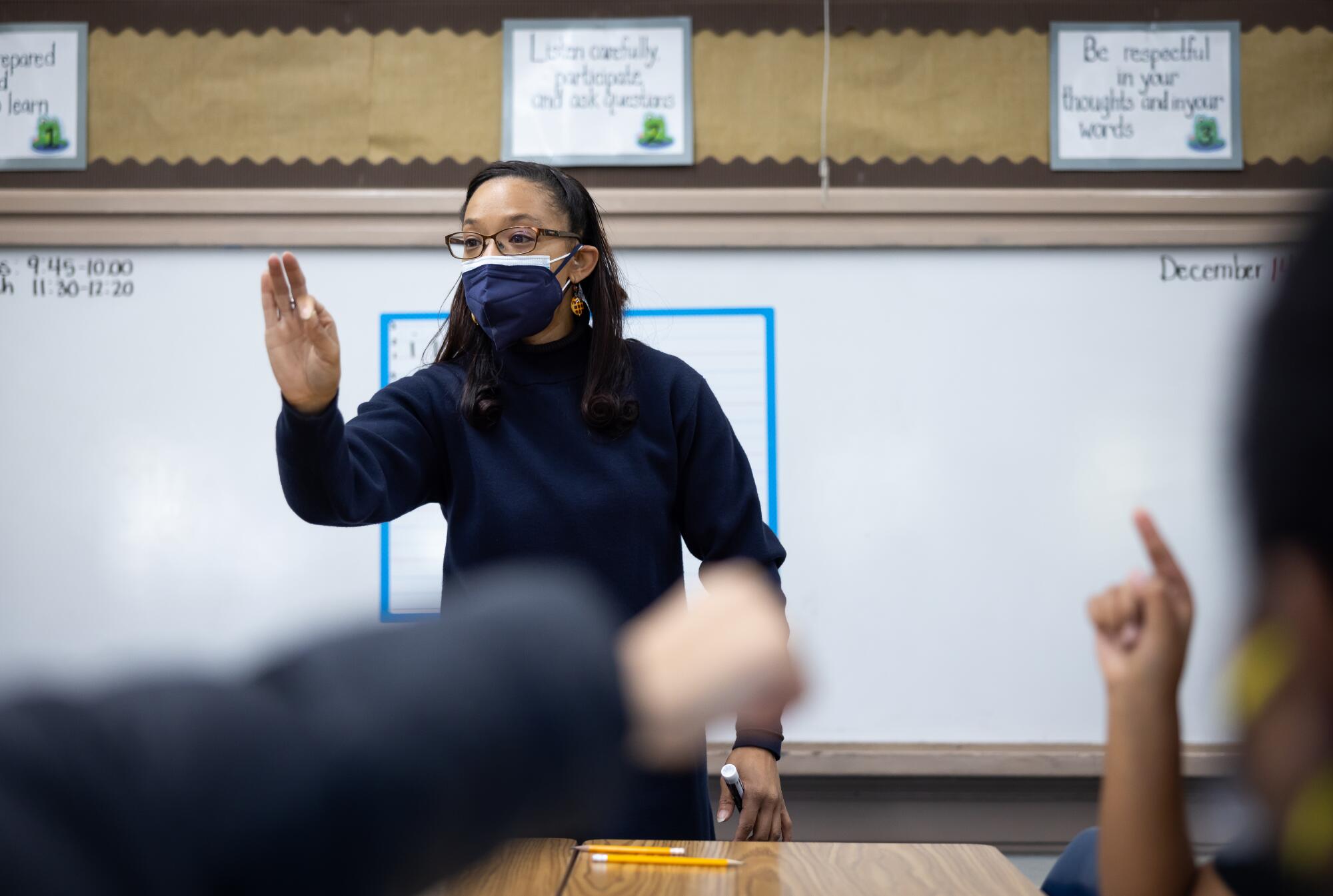 Teacher Tyara Brooks shows how to hold a pencil during a cursive writing lesson.