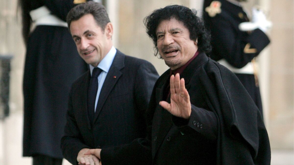French President Nicolas Sarkozy, left, welcomes Libyan leader Moammar Kadafi to Paris on Dec. 12, 2007.