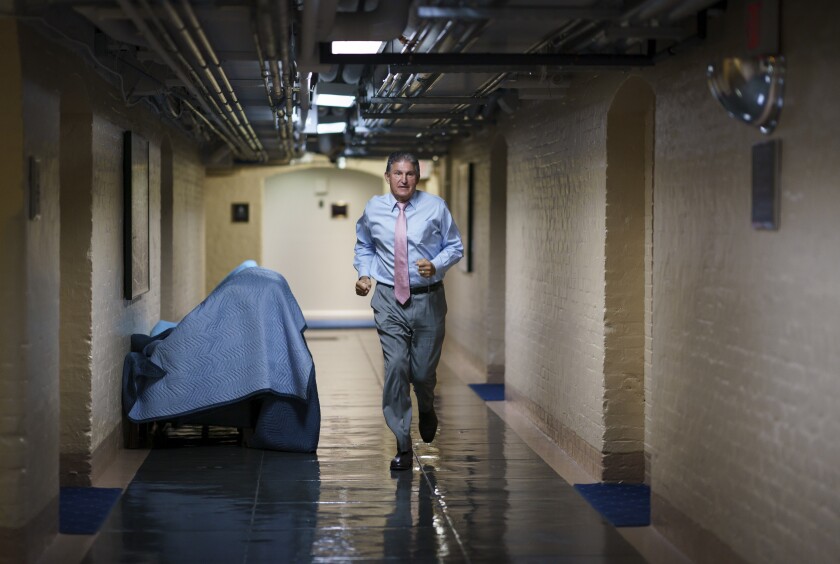 Sen. Joe Manchin, D-W.Va., one of the key Senate infrastructure negotiators, rushes back to a basement room at the Capitol as he and other Democrats work behind closed doors, in Washington, Wednesday, June 16, 2021. (AP Photo/J. Scott Applewhite)