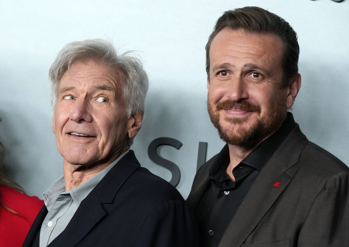 Harrison Ford, left, a cast member in "Shrinking," looks over at fellow cast member Jason Segel at the premiere of the Apple TV+ series, Thursday, Jan. 26, 2023, at the Directors Guild of America in Los Angeles. (AP Photo/Chris Pizzello)