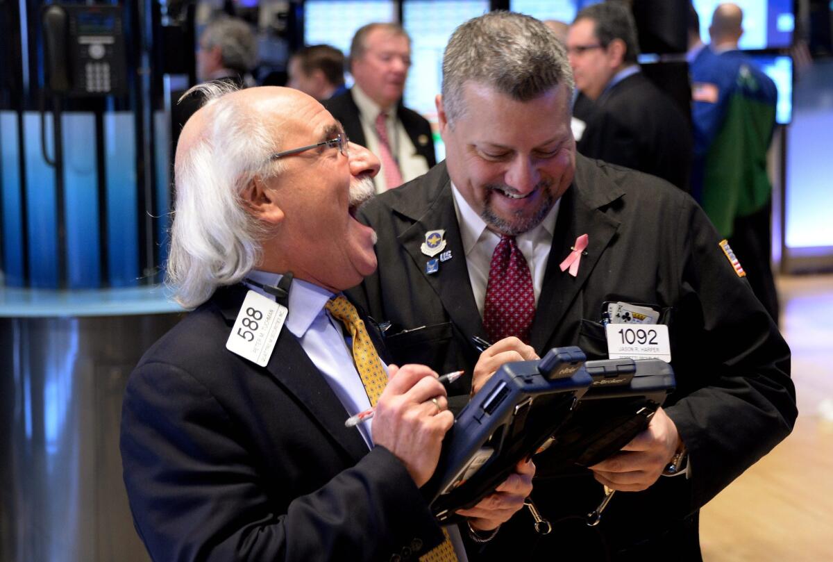 Traders work on the floor of the New York Stock Exchange on Thursday. The Dow closed the day up 421 points.