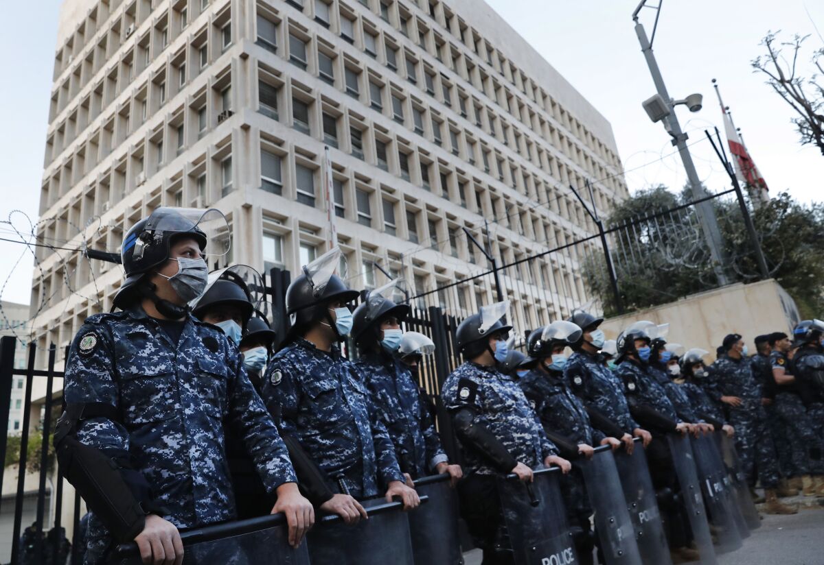 FILE - In this April 23, 2020, file photo, Lebanese riot police stand guard in front the central bank building, where the anti-government demonstrators protest against the Lebanese central bank's governor Riad Salameh and the deepening financial crisis, in Beirut, Lebanon. Lebanon's incoming Finance Minister Youssef El Khalil signed a contract on Friday, Sept. 17, 2021 with a New-York-based company, Alvarez & Marsal, to conduct a forensic audit of the country's central bank, a key demand of the international community to restore confidence in the crisis-struck country. (AP Photo/Hussein Malla, File)