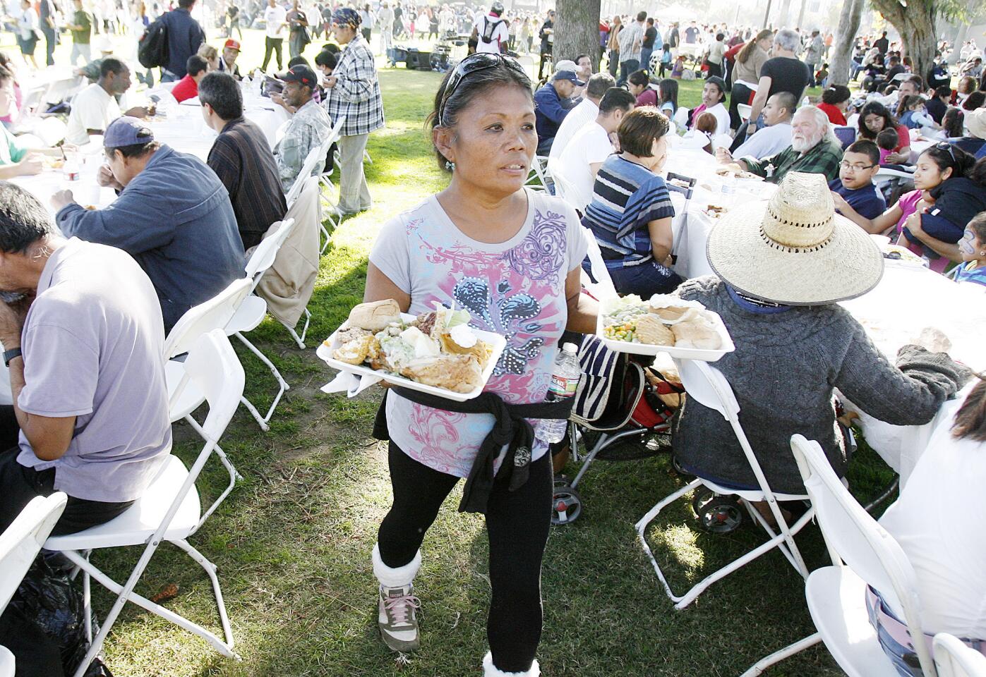 Monalyn Tarin, who is homeless in Pasadena, looks for her son carrying two plates of food through a crowded dining area at Central Park in Pasadena where Union Station Homeless Services served over 6,000 meals for the 35th Thanksgiving Dinner-in-the-Park on Thanksgiving on Thursday, November 22, 2012.