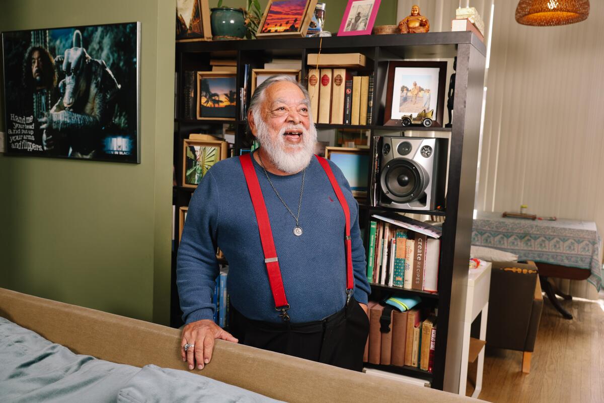 Sergio Calderon wearing a blue long sleeve shirt and red suspenders 