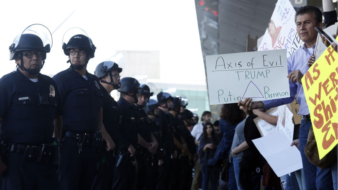Police keep an eye on people who continue to protest at the Tom Bradley International Terminal at LAX.