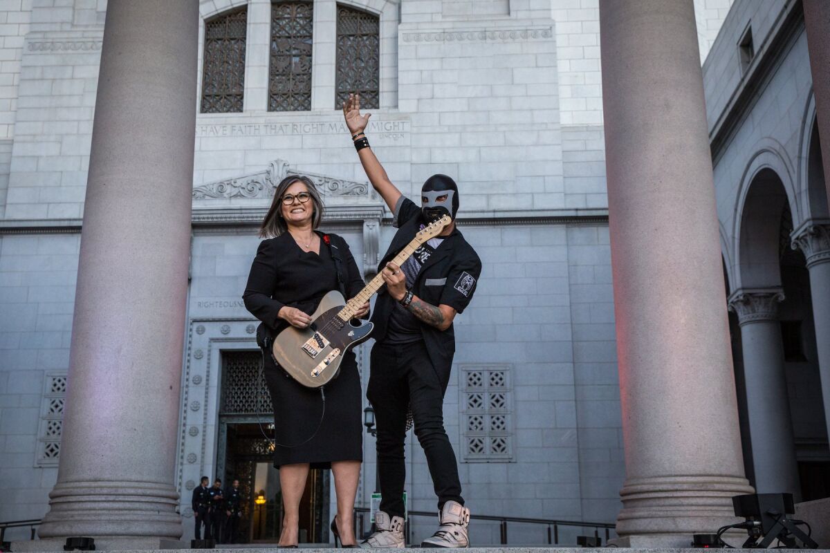 Councilwoman Monica Rodriguez strums the guitar of one of the event's performers in 2018.