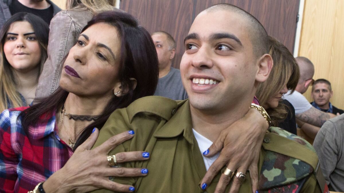 Israeli soldier Elor Azaria is embraced by his mother at the start of his sentencing hearing in Tel Aviv.