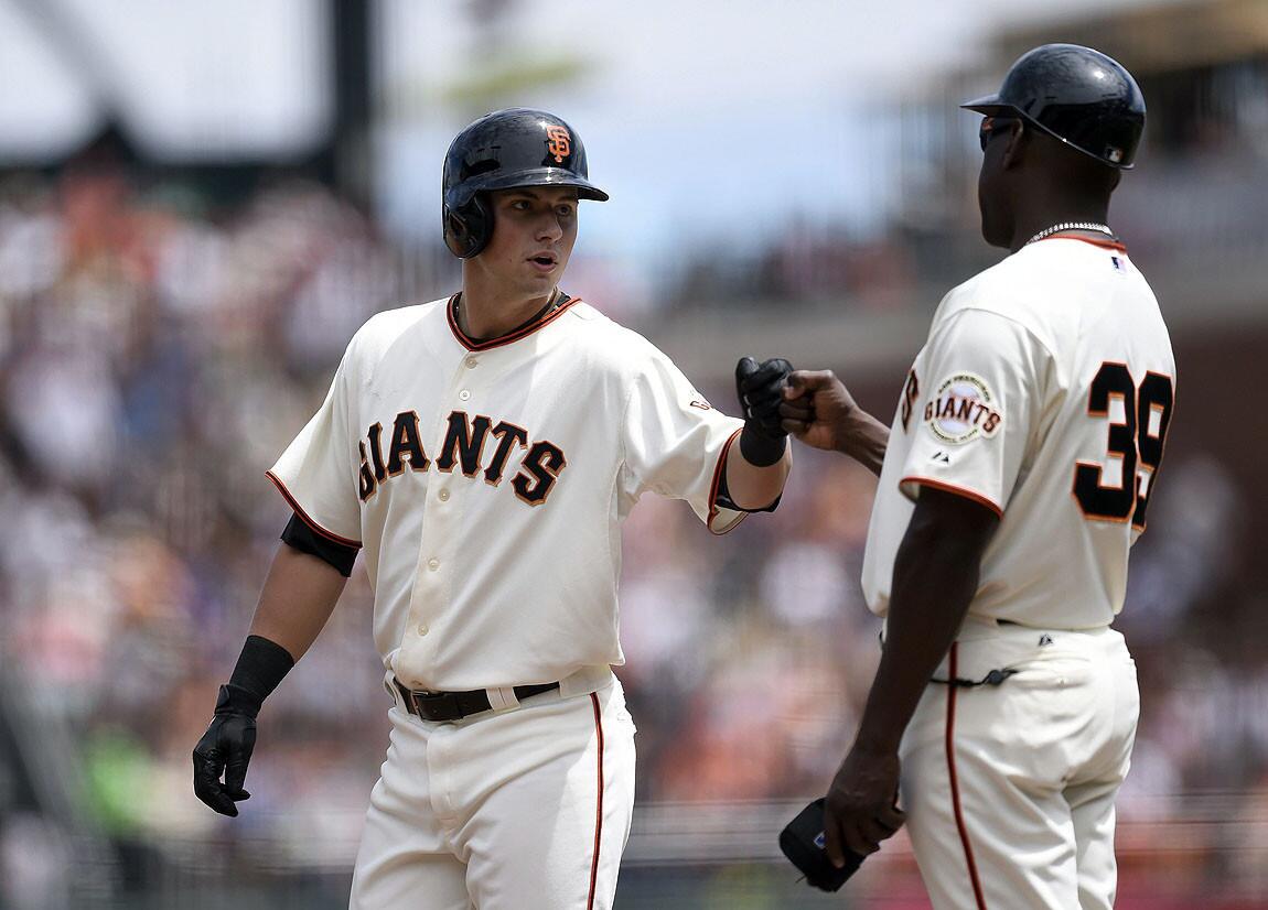 Giants rookie Joe Panik (left) greets first base coach Roberto Kelly after hitting a single in the second inning.