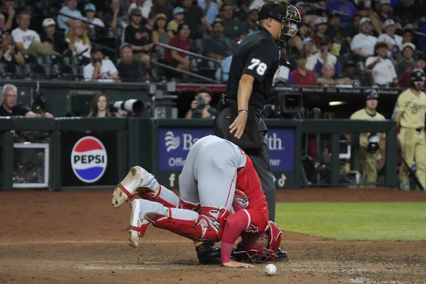 Los Angeles Angels catcher Logan O'Hoppe reacts after getting hit with a foul ball during the sixth inning of the team's baseball game against the Arizona Diamondbacks, Tuesday, June 11, 2024, in Phoenix. (AP Photo/Rick Scuteri)