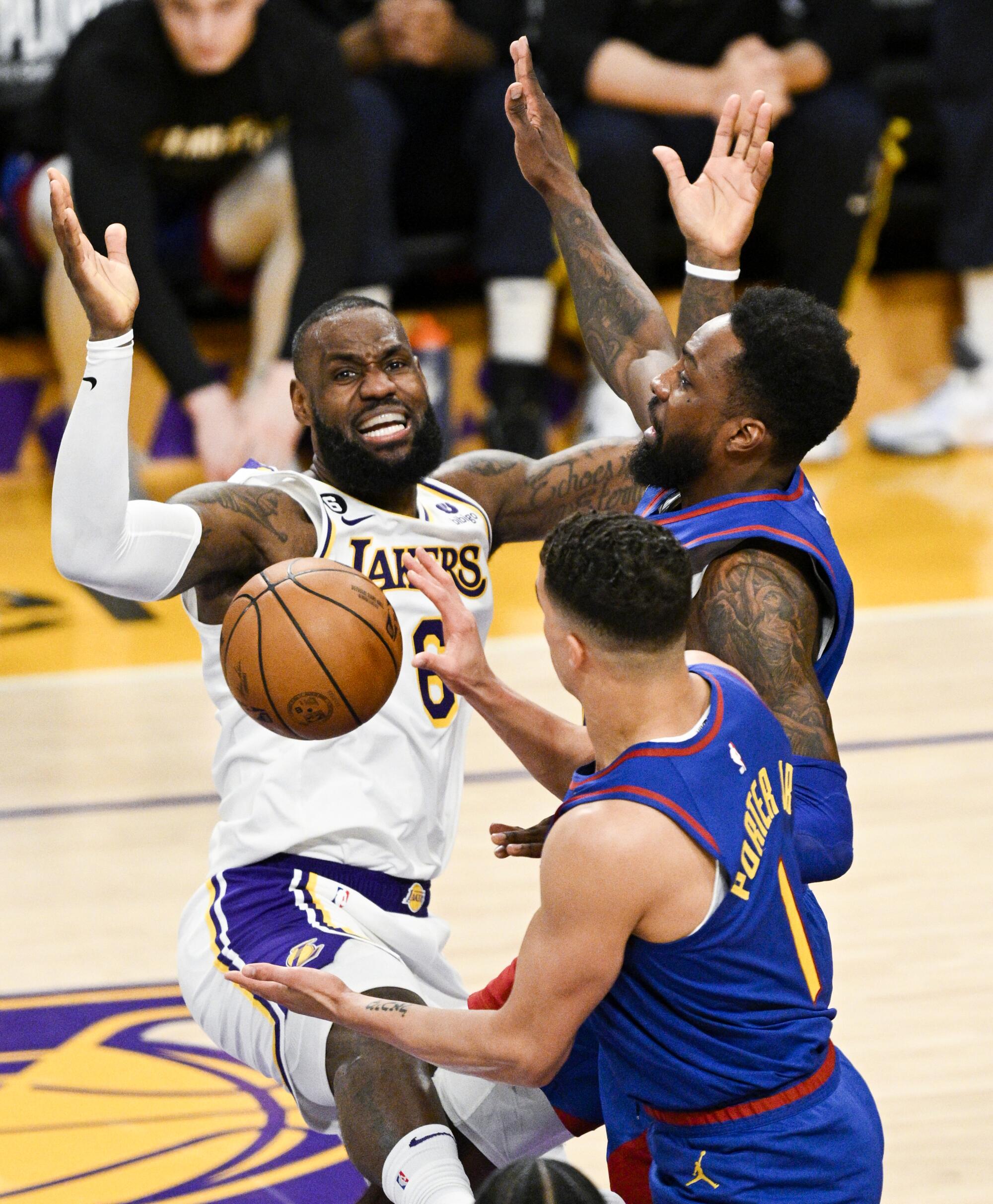 Lakers forward LeBron James reacts after losing the ball in front of Nuggets' Jeff Green and Michael Porter Jr.