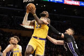 Lakers forward LeBron James is fouled by Kings center Alex Len while driving to the basket 