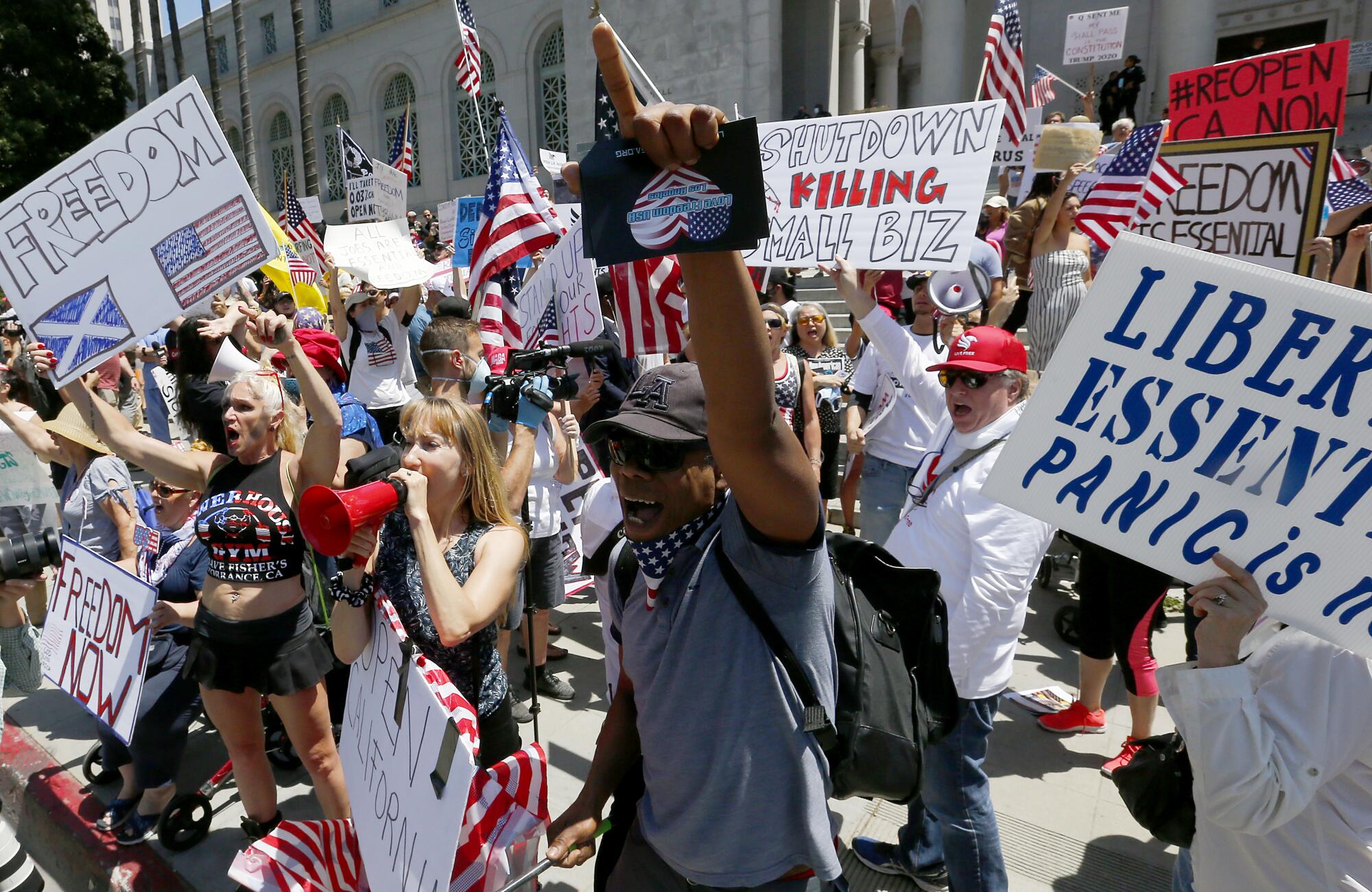 Hundreds of people converged downtown to call on Gov. Gavin Newsom to immediately lift stay-at-home orders outside L.A. City Hall.