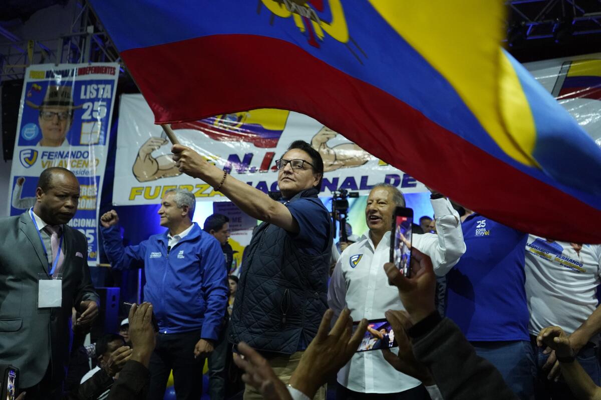 El candidato presidencial Fernando Villavicencio ondea una bandera nacional de Ecuador