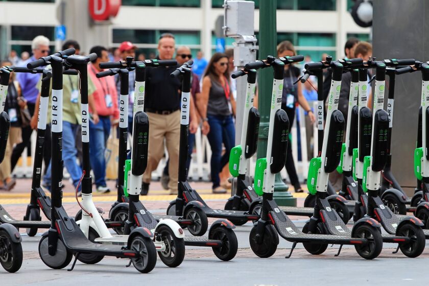 This file photo shows a large number of rental scooters parked near the Convention Center along Fifth Avenue in July 2018.