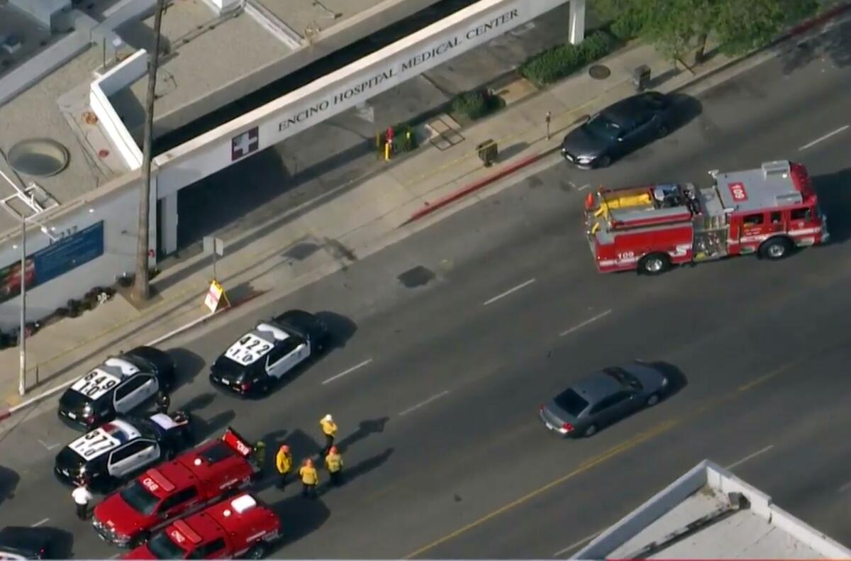 Aerial view of police cruisers and firetrucks in the street outside a hospital