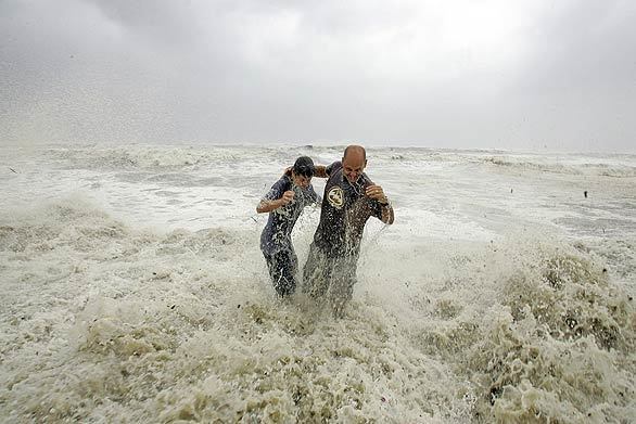 Steve Owen, right, and his son Austin, 13, are swamped by a wave from Hurricane Ike while standing on the sea wall in Galveston, Texas.