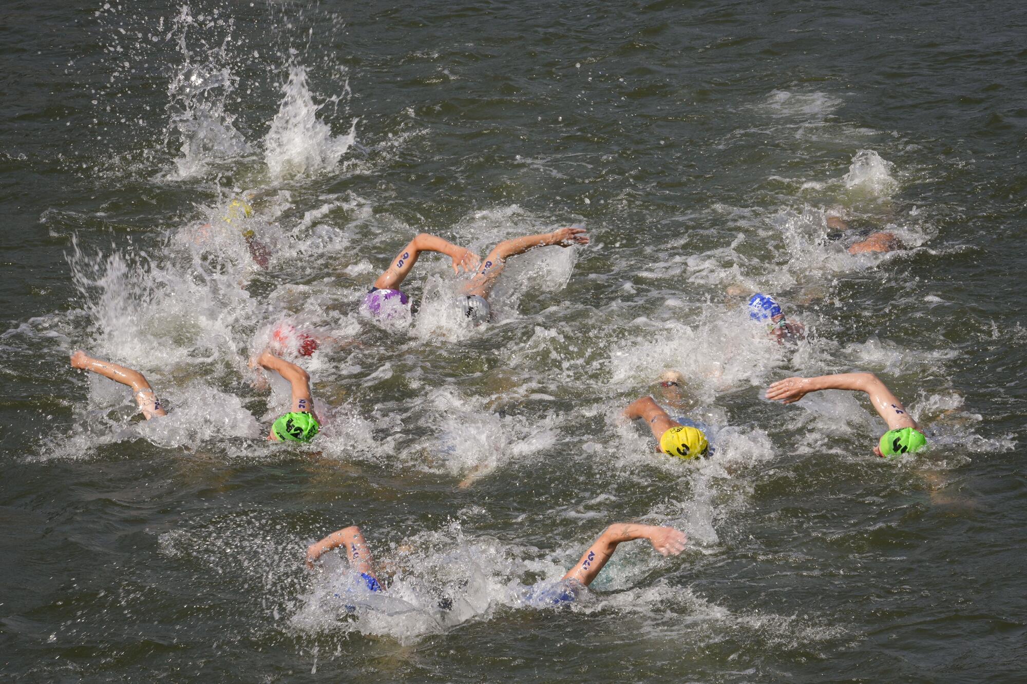 Athletes swim in the Seine River during the men's individual triathlon on Wednesday.