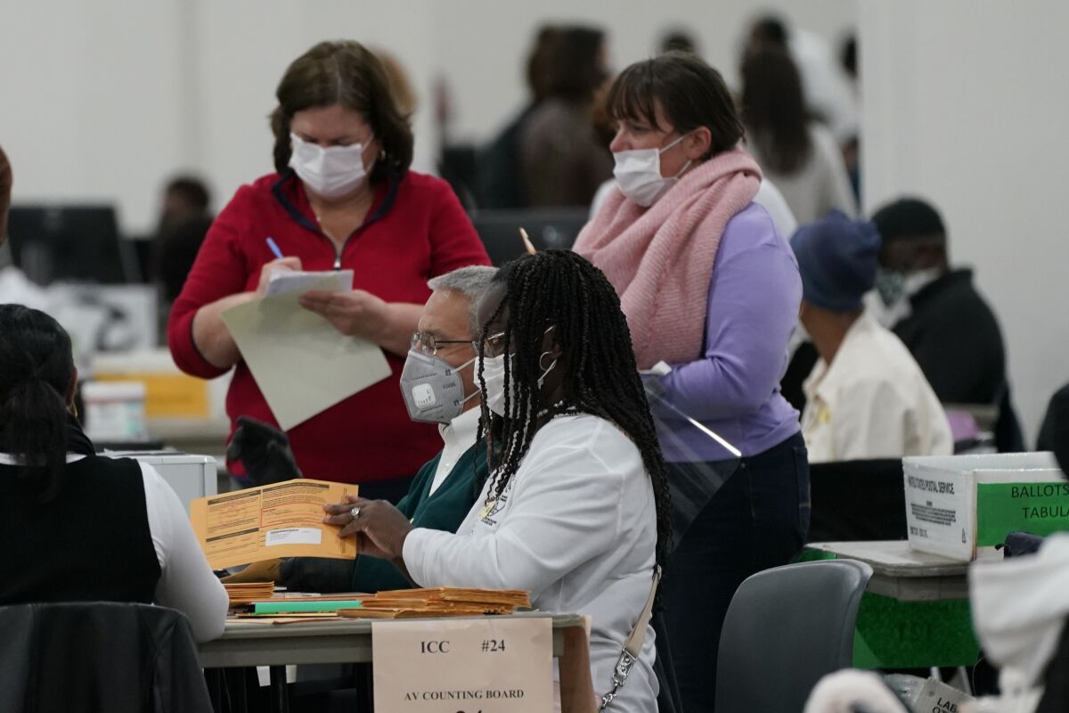 Absentee ballots are processed at the central counting board, Wednesday, Nov. 4, 2020, in Detroit. (AP Photo/Carlos Osorio)