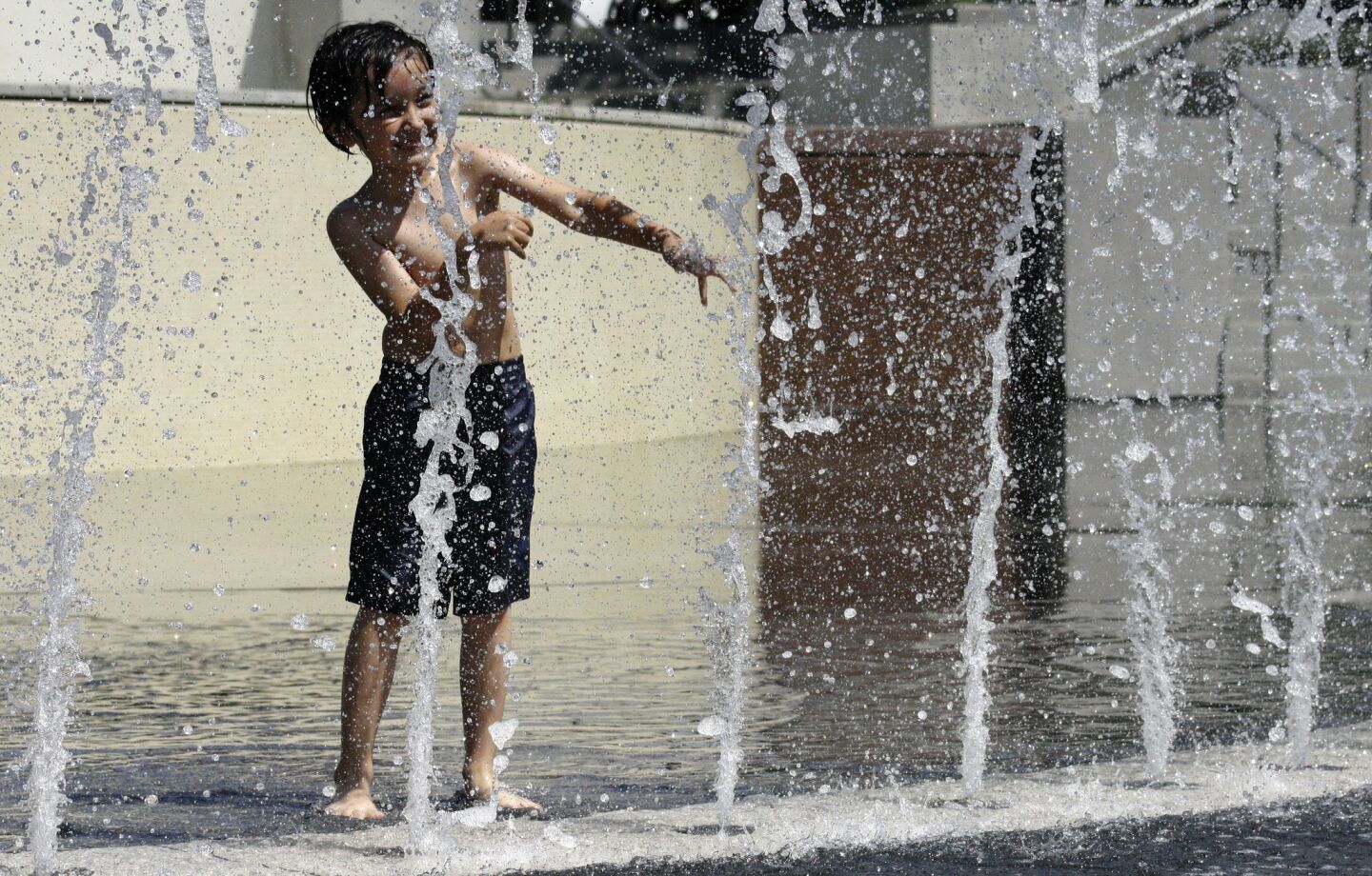 Leonardo Zenaidi, 5, plays in the fountain at Grand Park in downtown Los Angeles as temperatures continue to climb Friday.