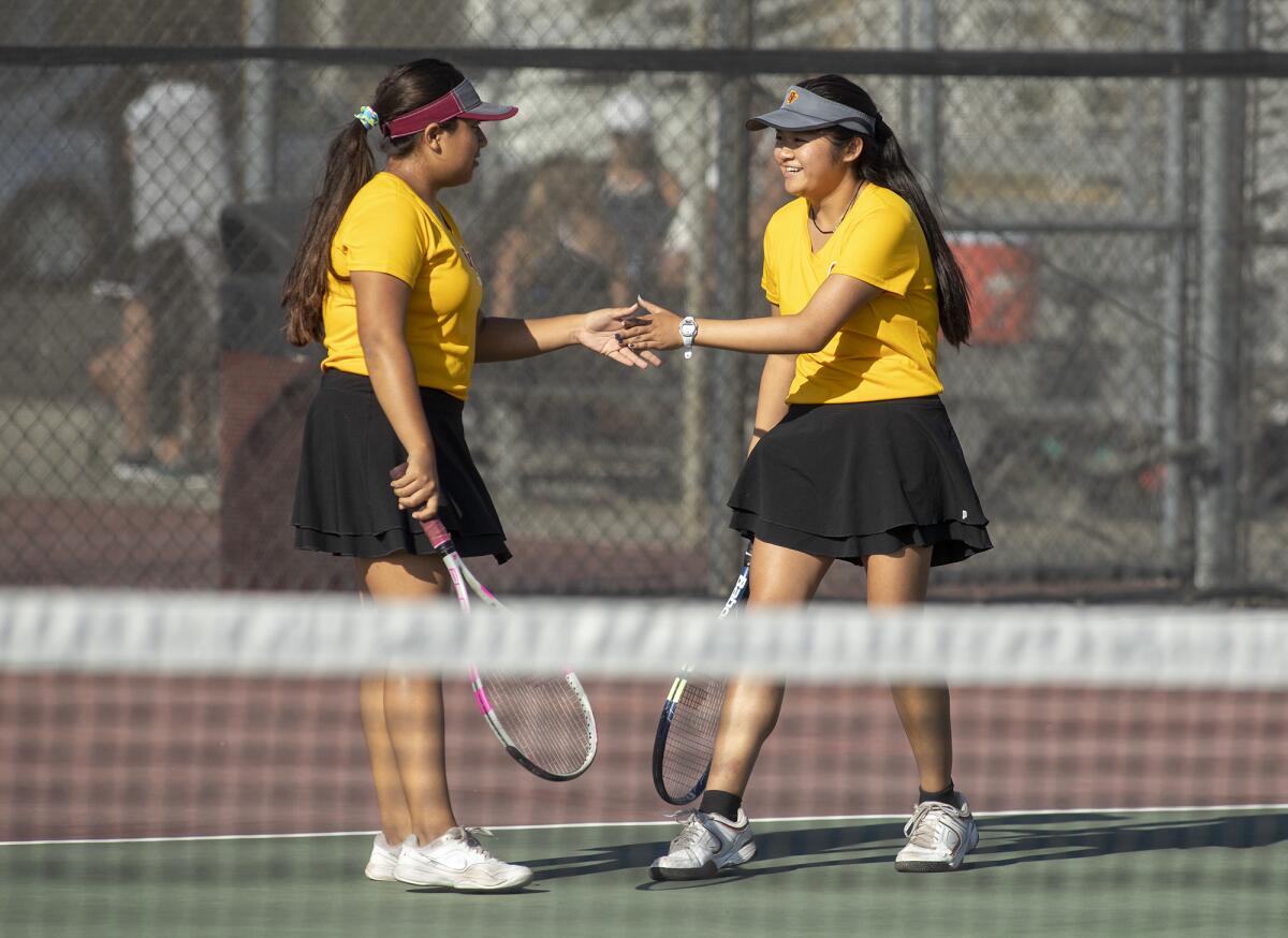 Ocean View's Lydia Villanueva, left, and her doubles partner Christina Ho high-five after winning a point in a Golden West League match against Godinez on Wednesday.