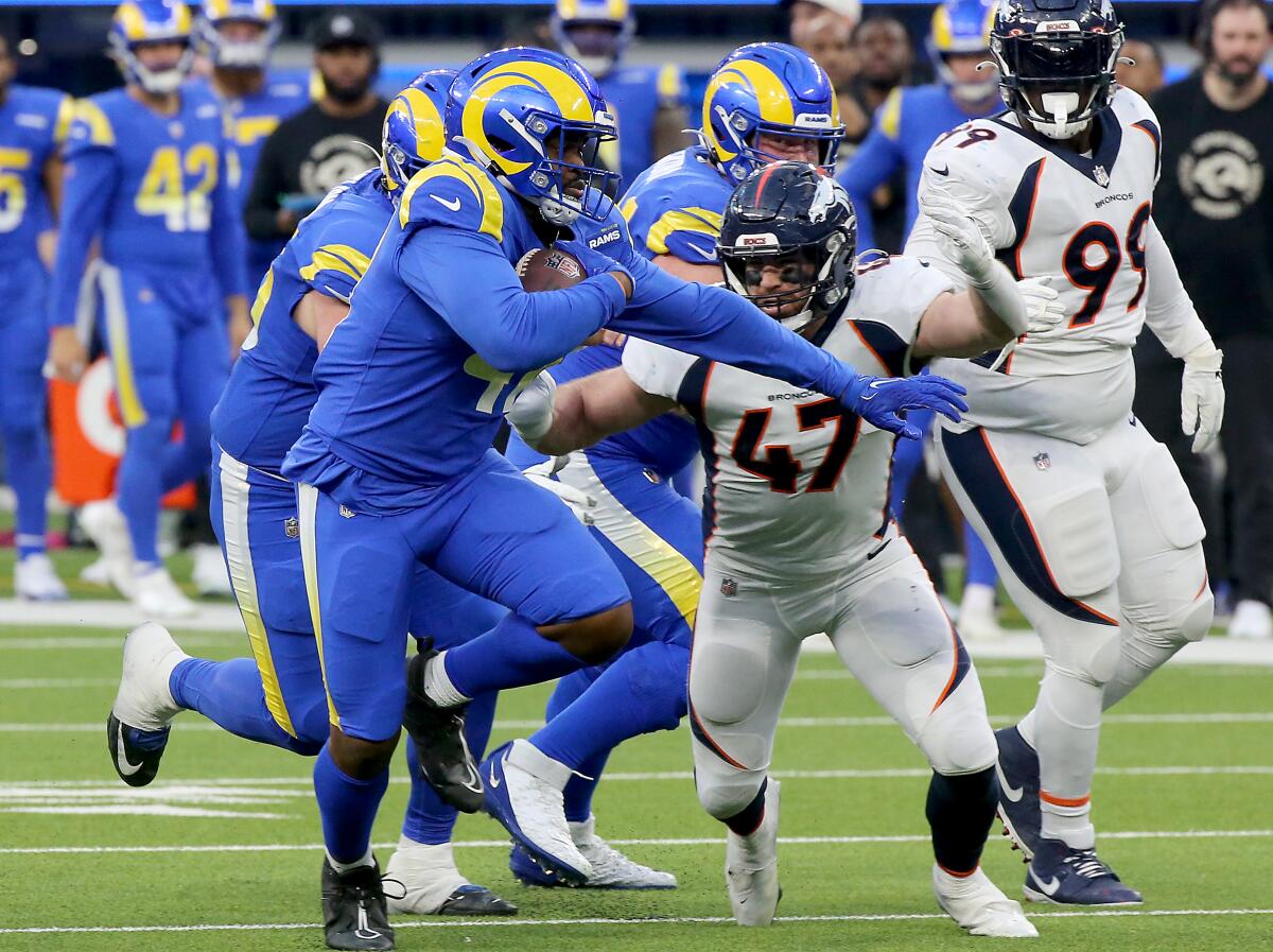 A Rams running back carries the ball during a game 